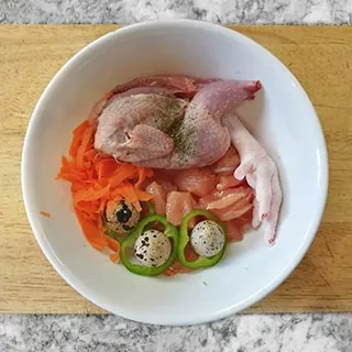 Plato con codorniz, patas de pollo, zanahoria rallada, pimiento verde y huevos de codorniz