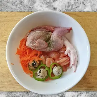 Plato con codorniz, patas de pollo, zanahoria, pimiento y huevos de codorniz