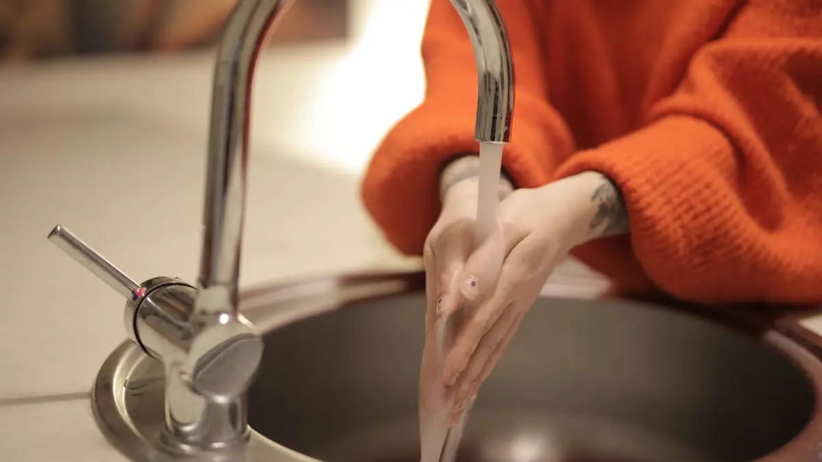 Una persona se lava las manos con agua y jabón